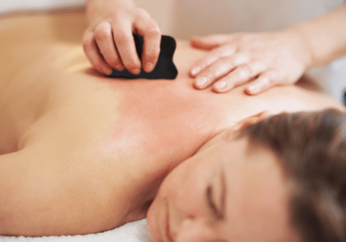 Utilisation du gua sha sur le dos de la cliente lors d'un massage
